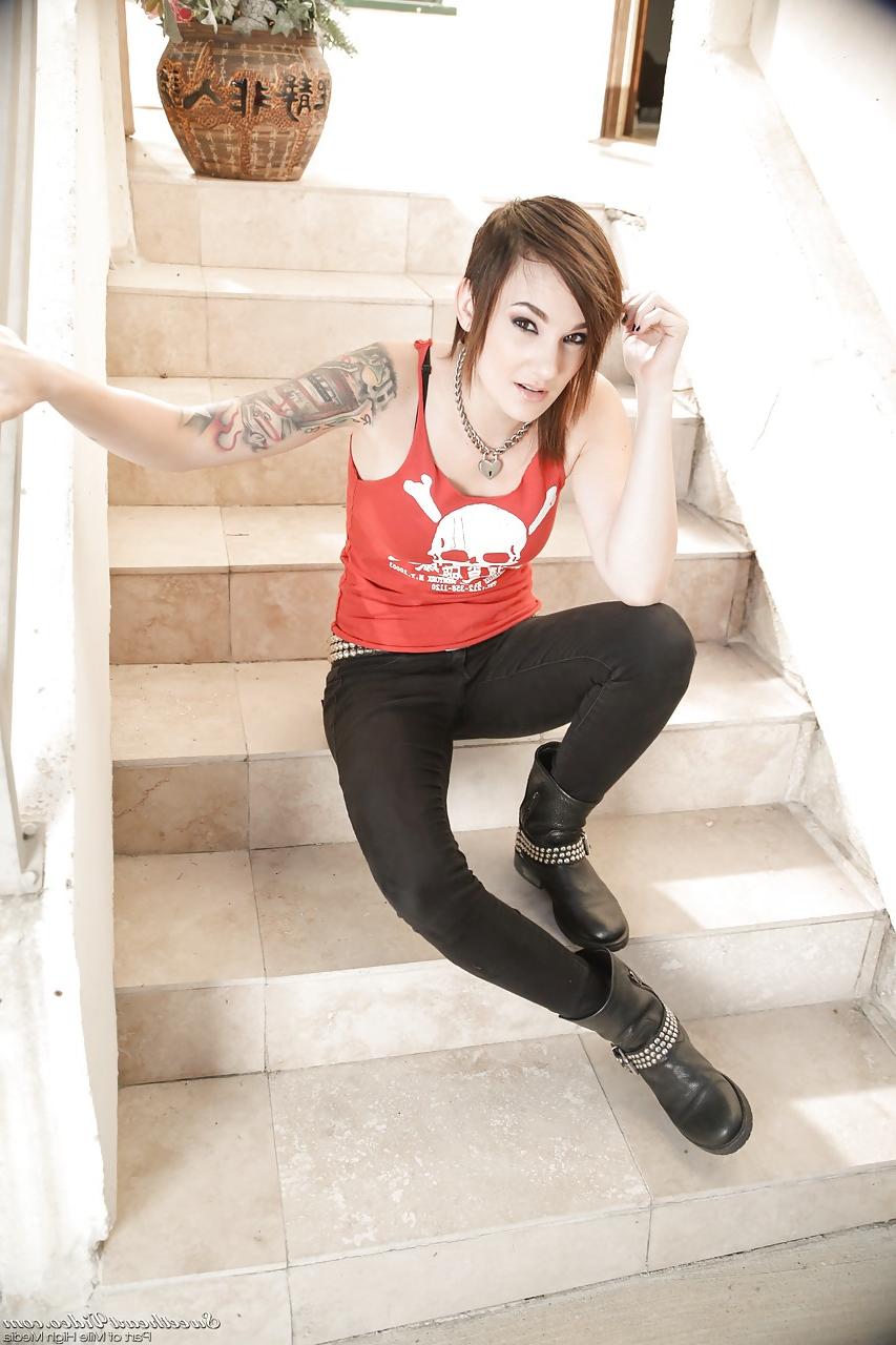 15P Tattooed erotic model Nikki Hearts undressing to pose naked on front steps