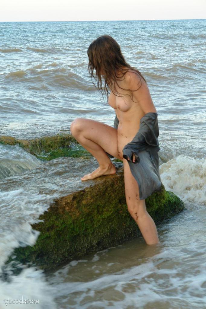 16P Brunette teen Petra E gets naked on the beach in "Surf In"