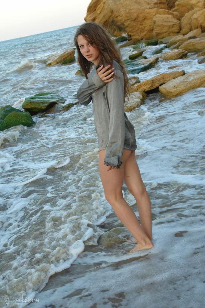 16P Brunette teen Petra E gets naked on the beach in "Surf In"