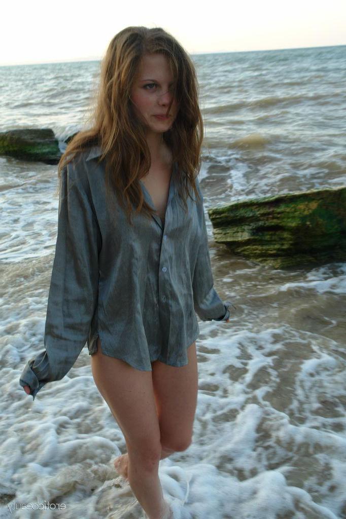 16P Brunette teen Petra E gets naked on the beach in "Surf In"