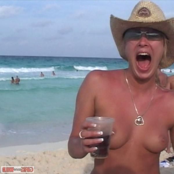 10P Young topless babe on the beach drinking a beer