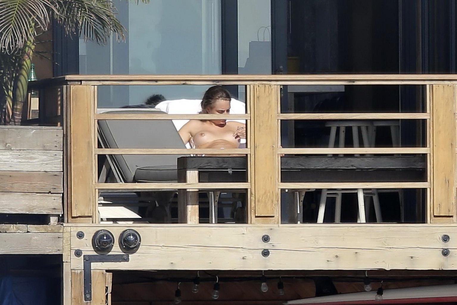 16P Cara Delevingne tanning topless on a balcony in Malibu