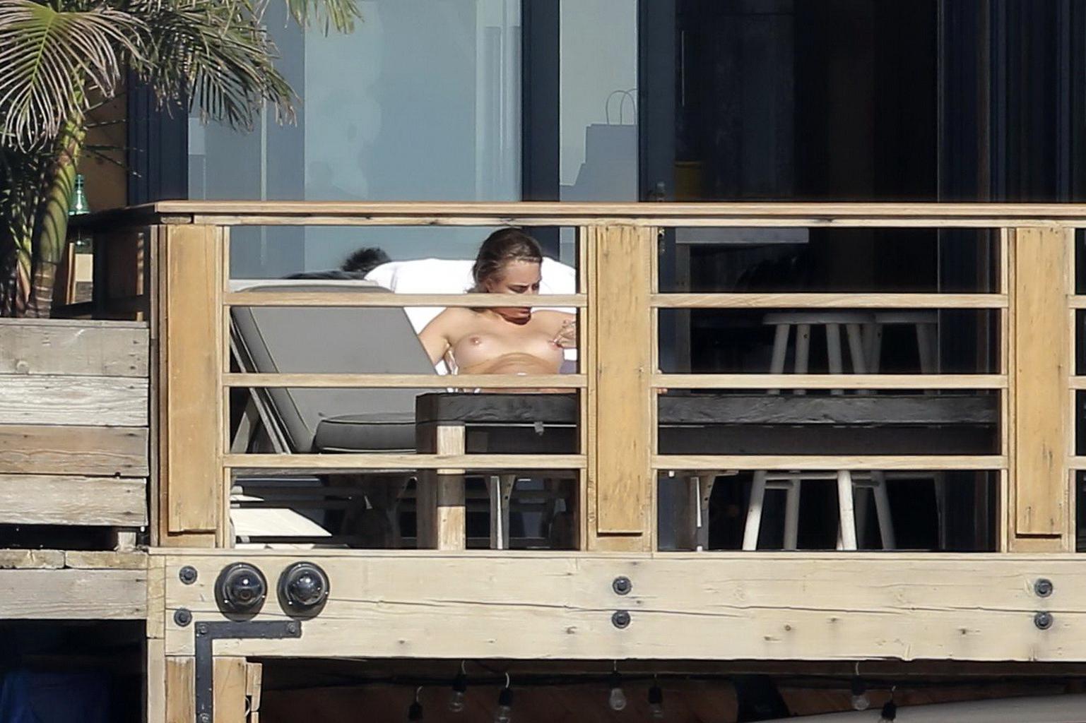 16P Cara Delevingne tanning topless on a balcony in Malibu