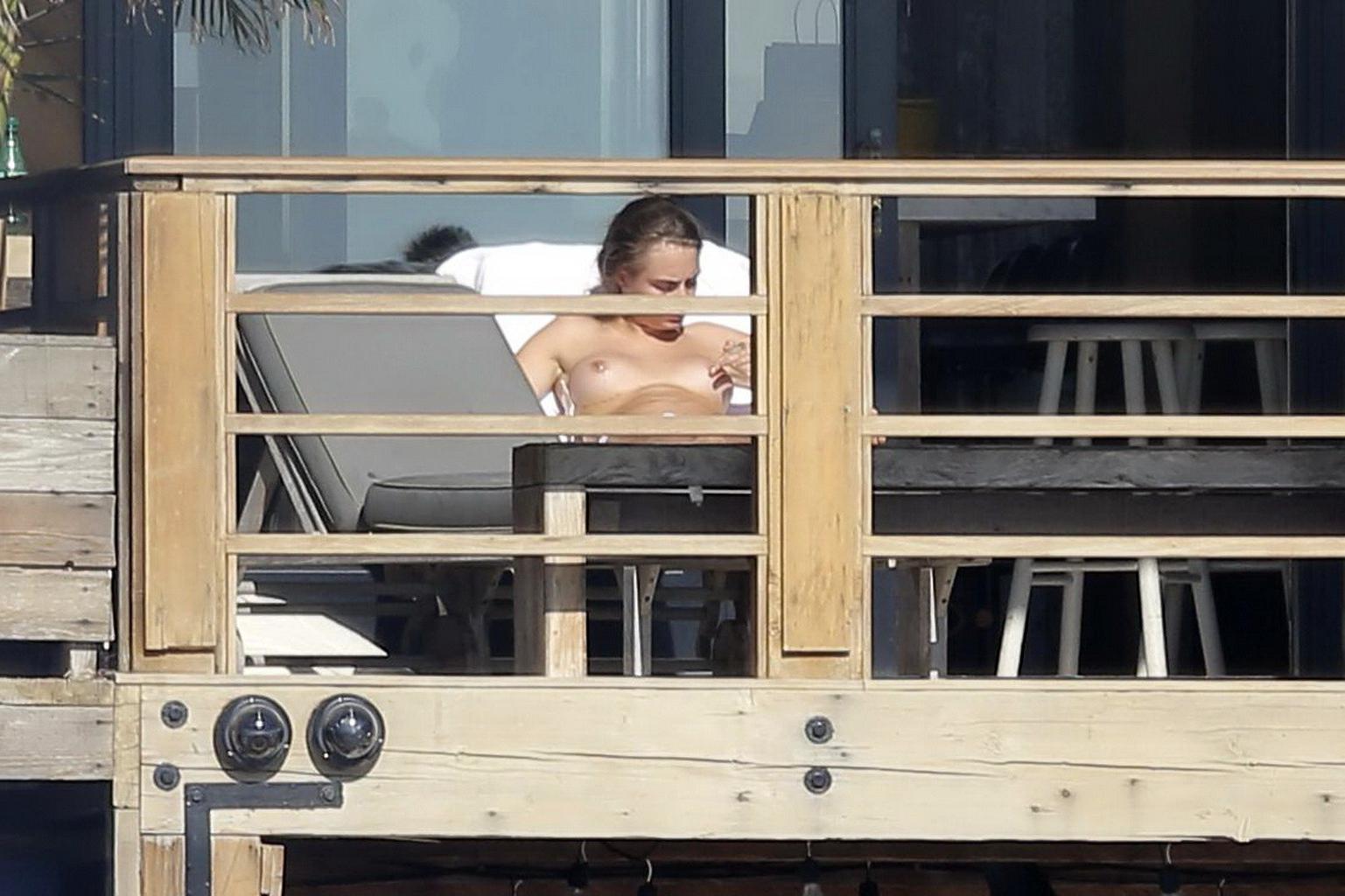 16P Cara Delevingne tanning topless on a balcony in Malibu