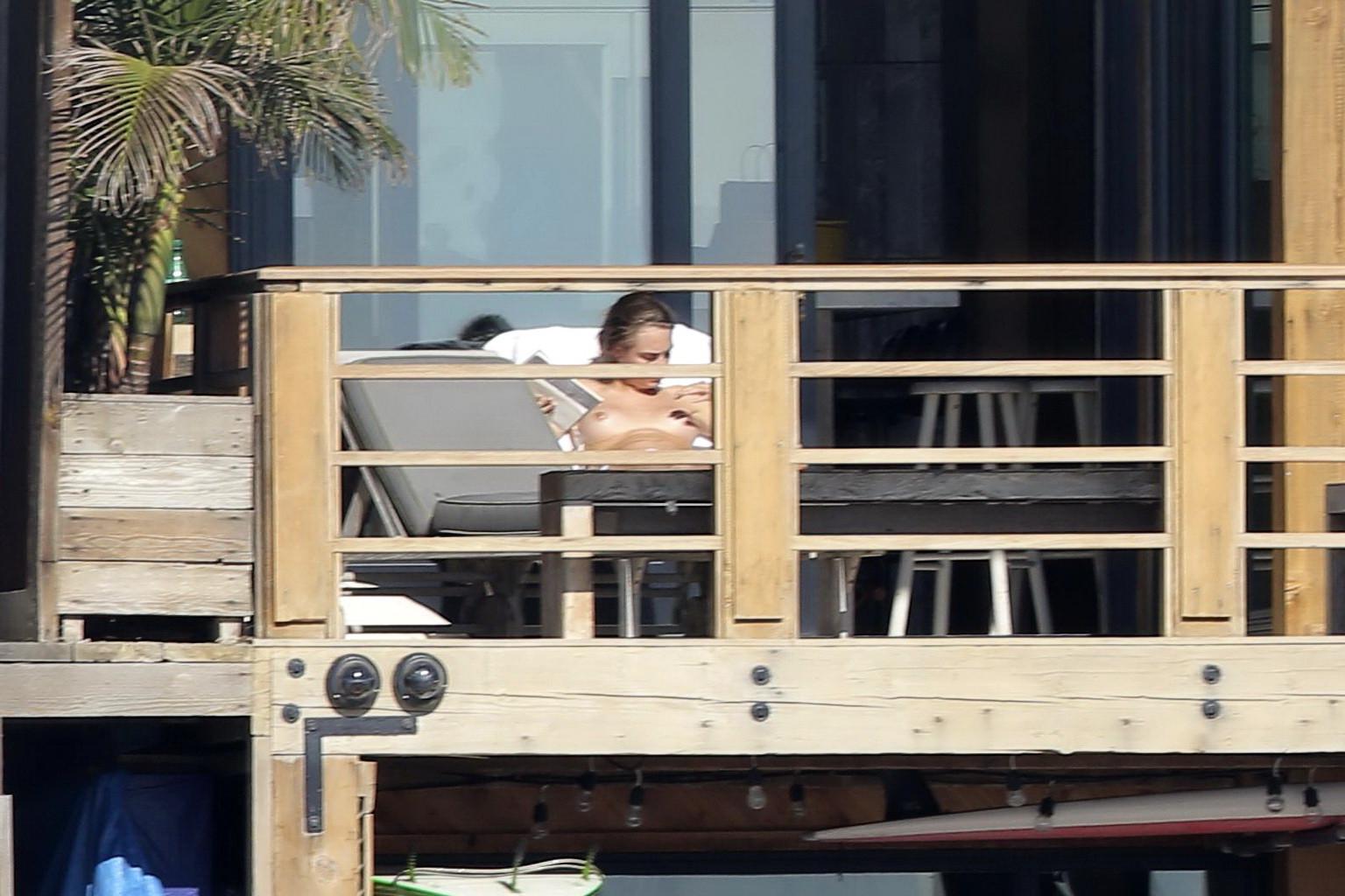 16P Cara Delevingne tanning topless on a balcony in Malibu