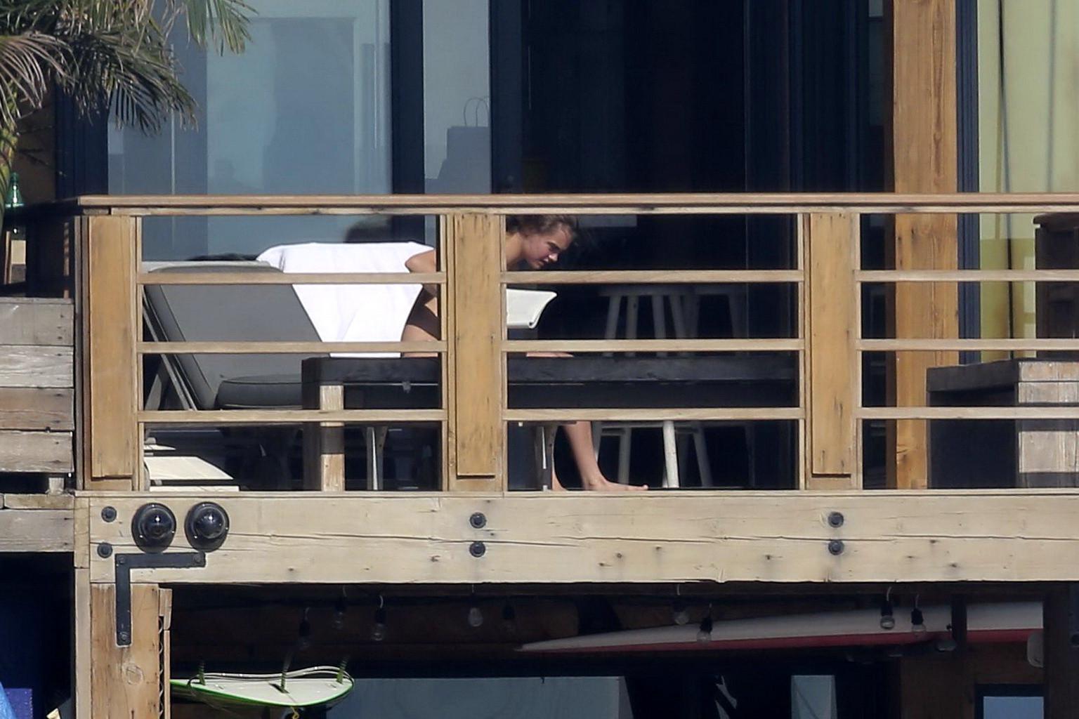 16P Cara Delevingne tanning topless on a balcony in Malibu