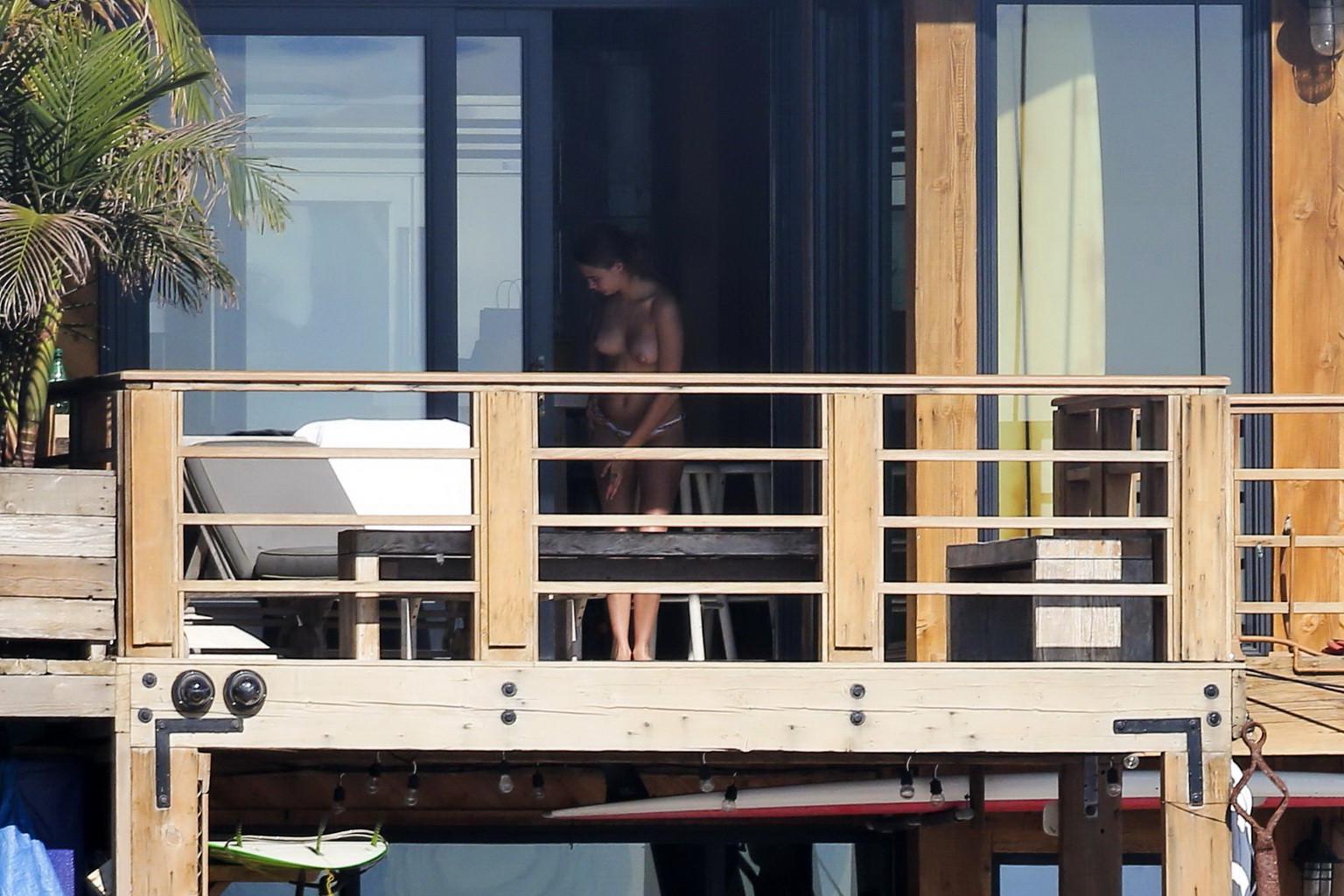 16P Cara Delevingne tanning topless on a balcony in Malibu