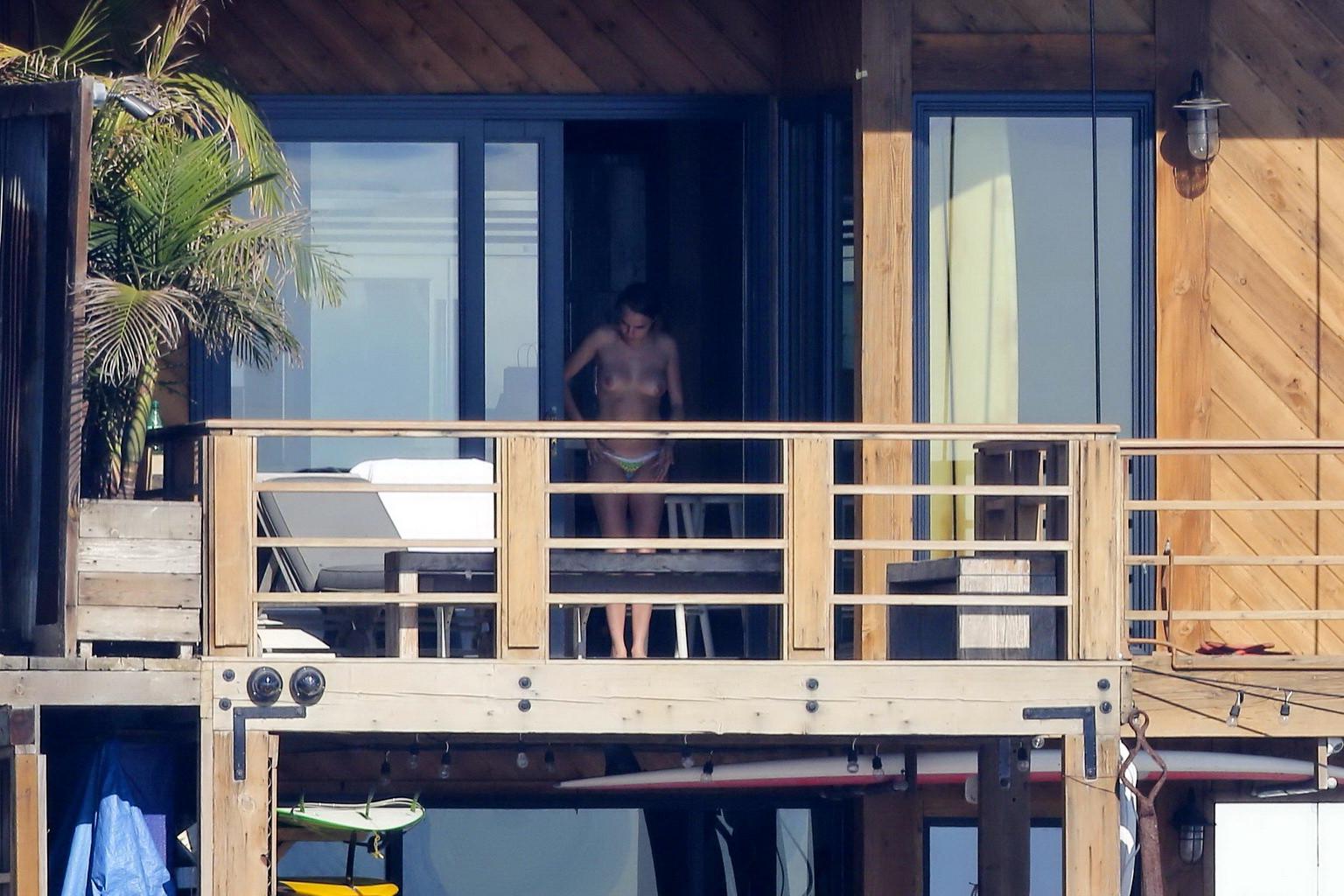 16P Cara Delevingne tanning topless on a balcony in Malibu