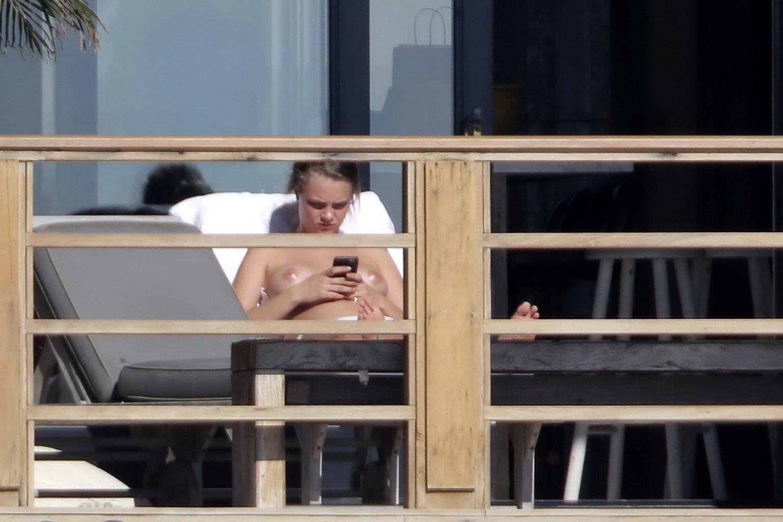 16P Cara Delevingne tanning topless on a balcony in Malibu