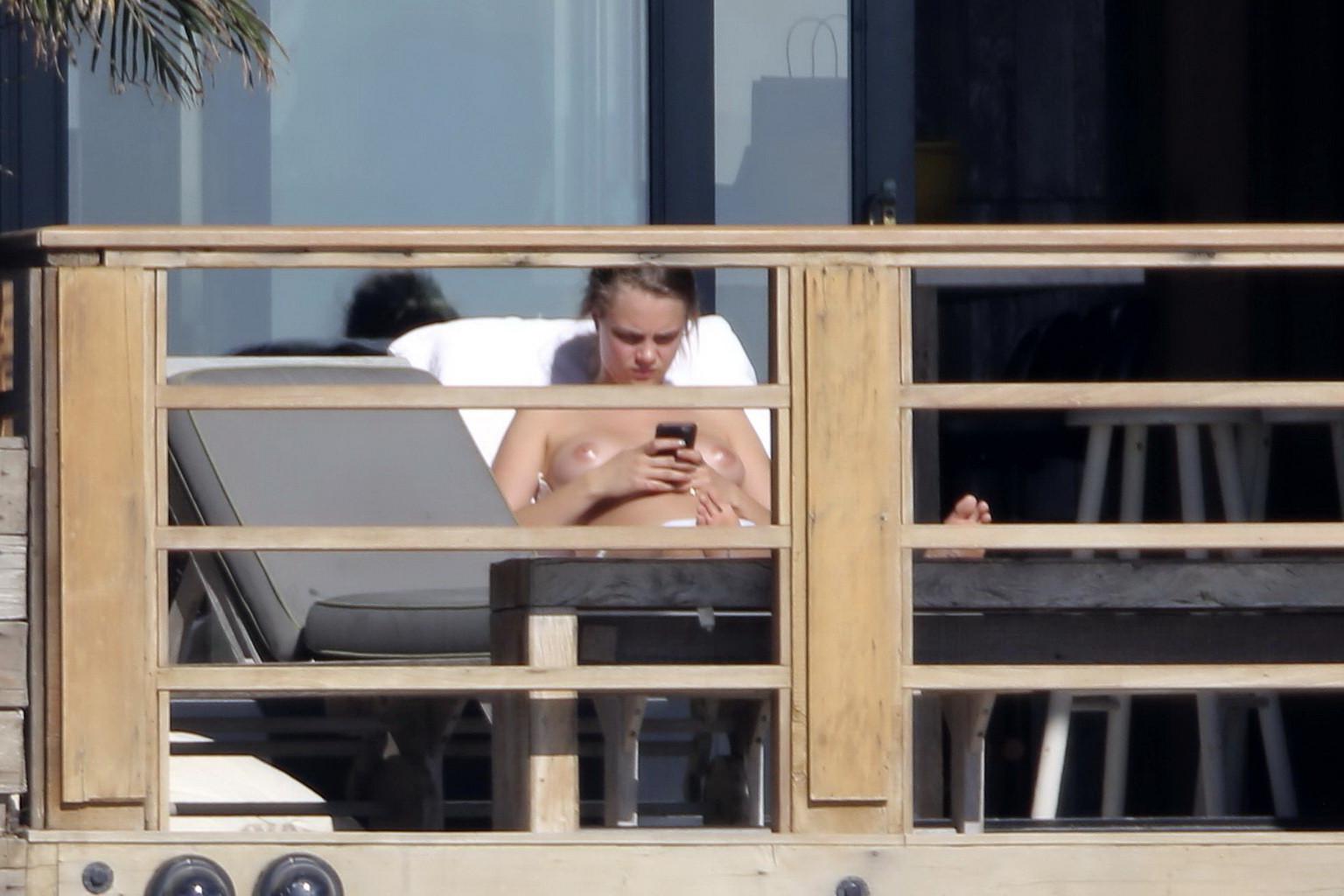 16P Cara Delevingne tanning topless on a balcony in Malibu