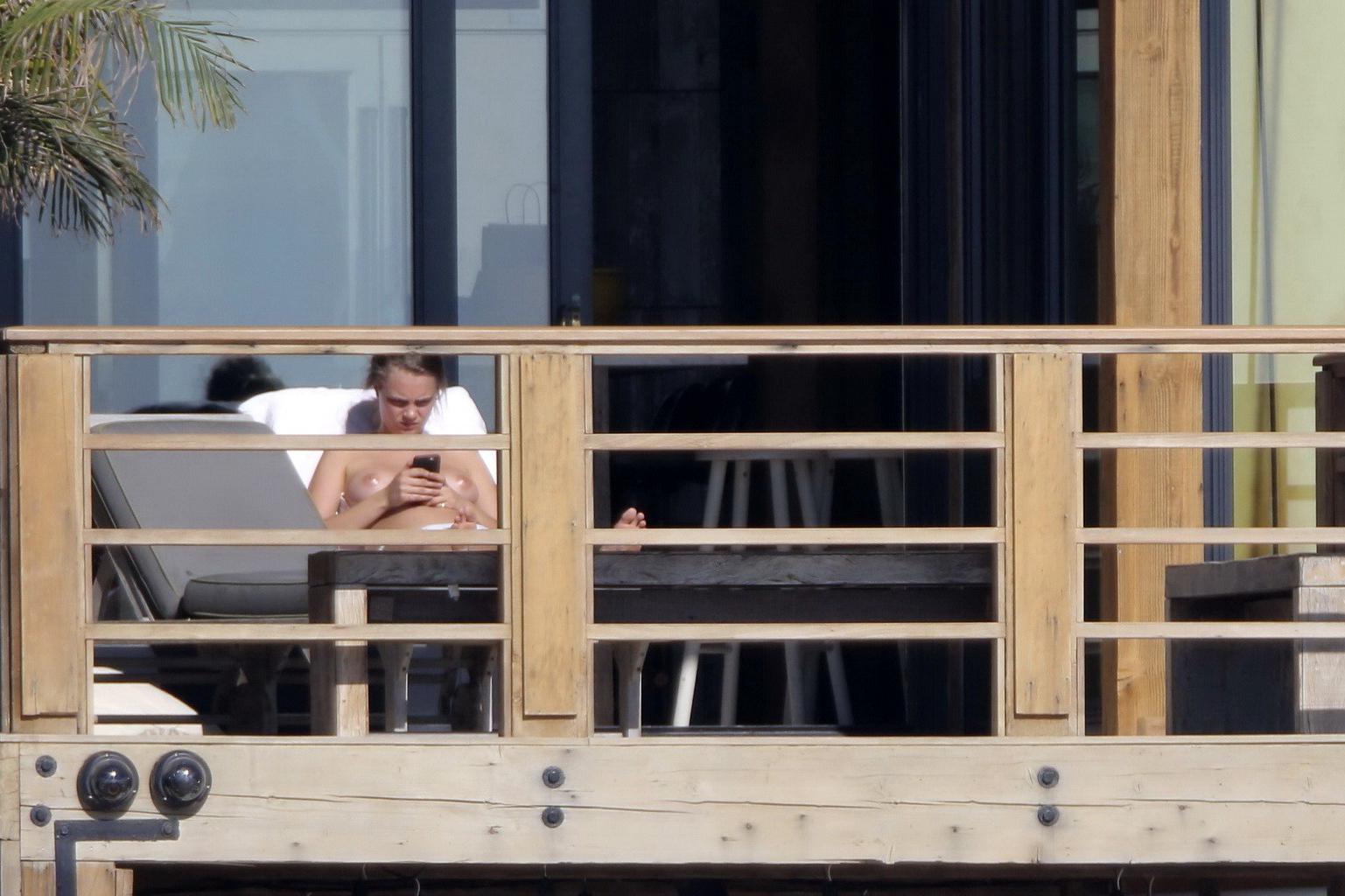 16P Cara Delevingne tanning topless on a balcony in Malibu