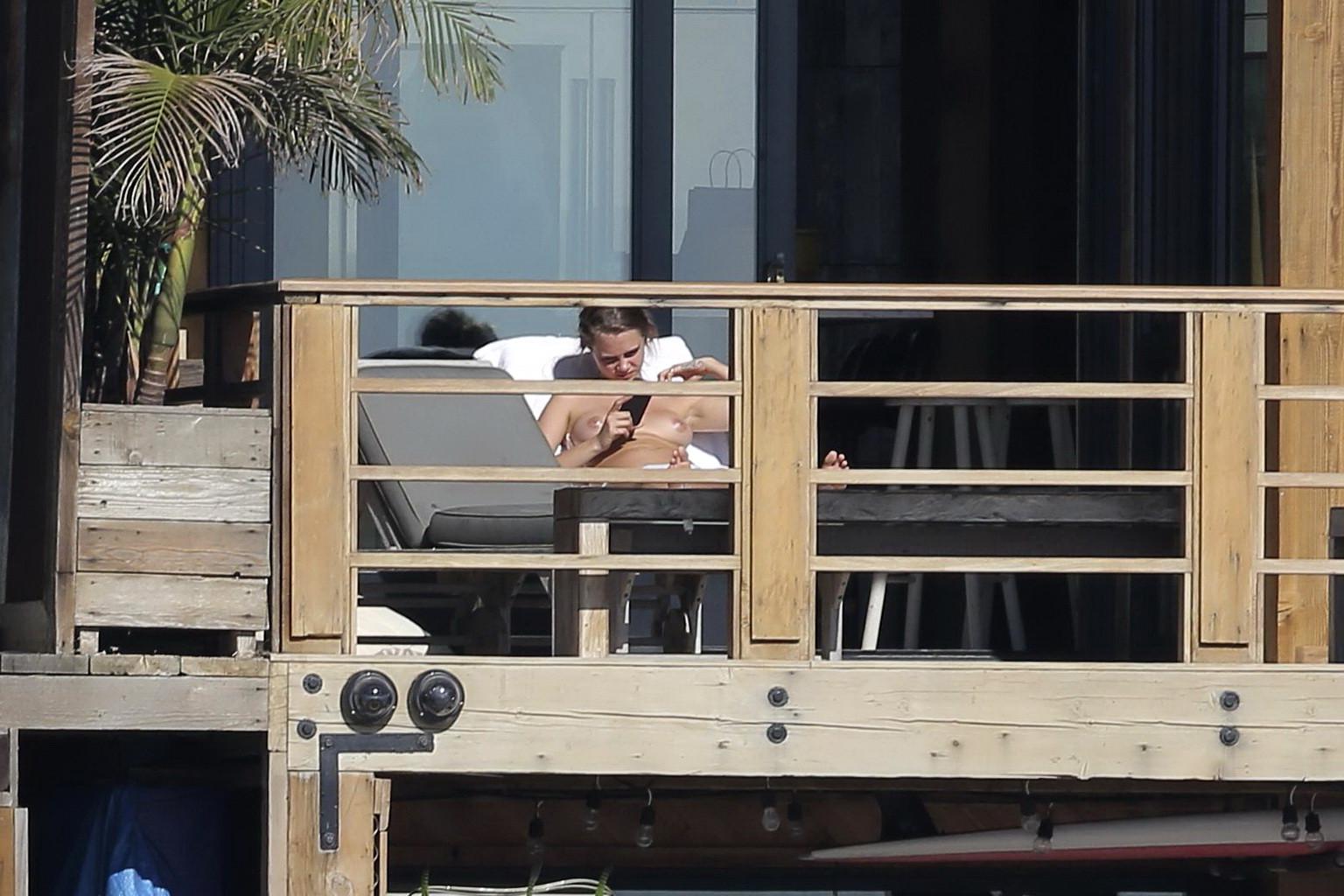 16P Cara Delevingne tanning topless on a balcony in Malibu