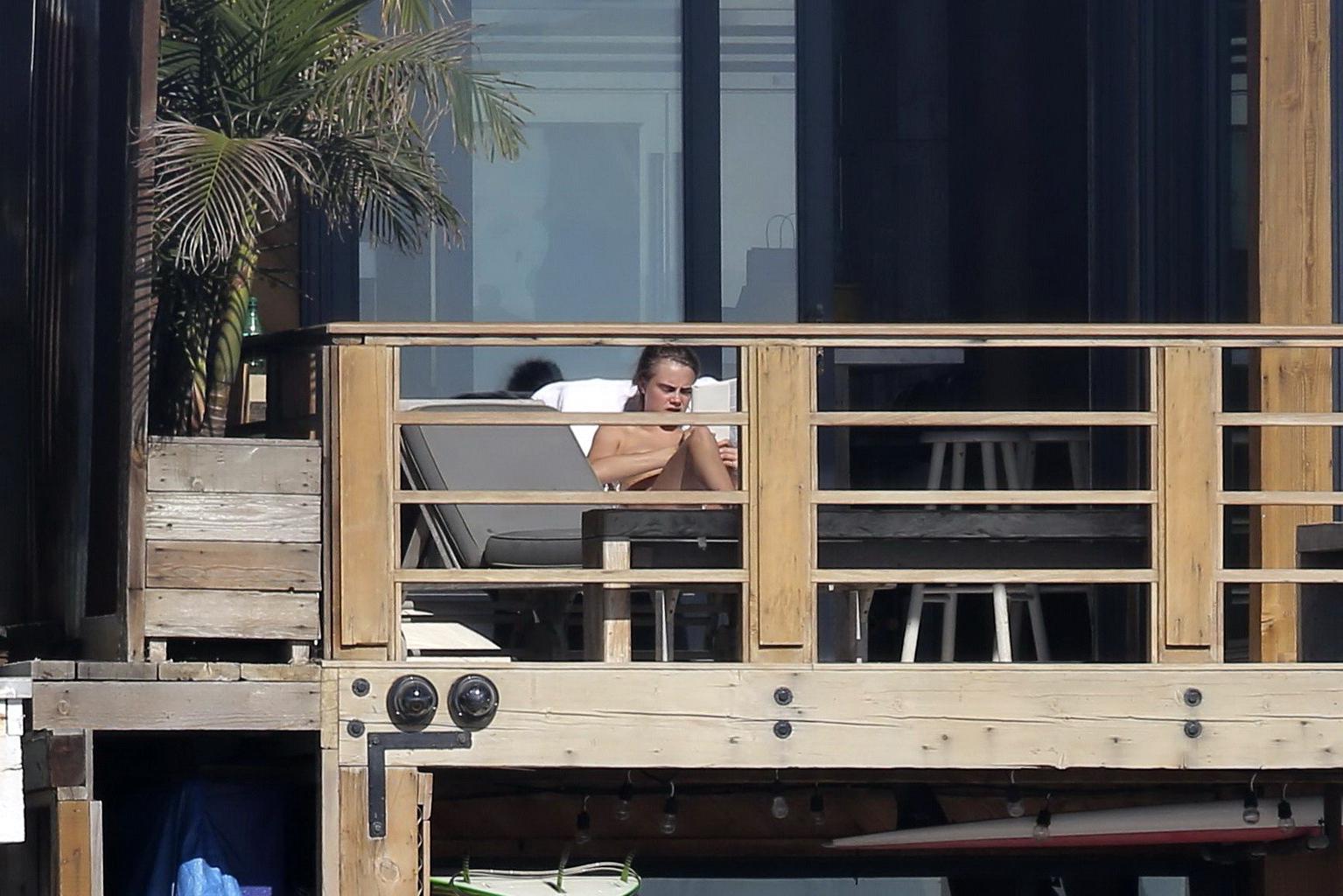 16P Cara Delevingne tanning topless on a balcony in Malibu