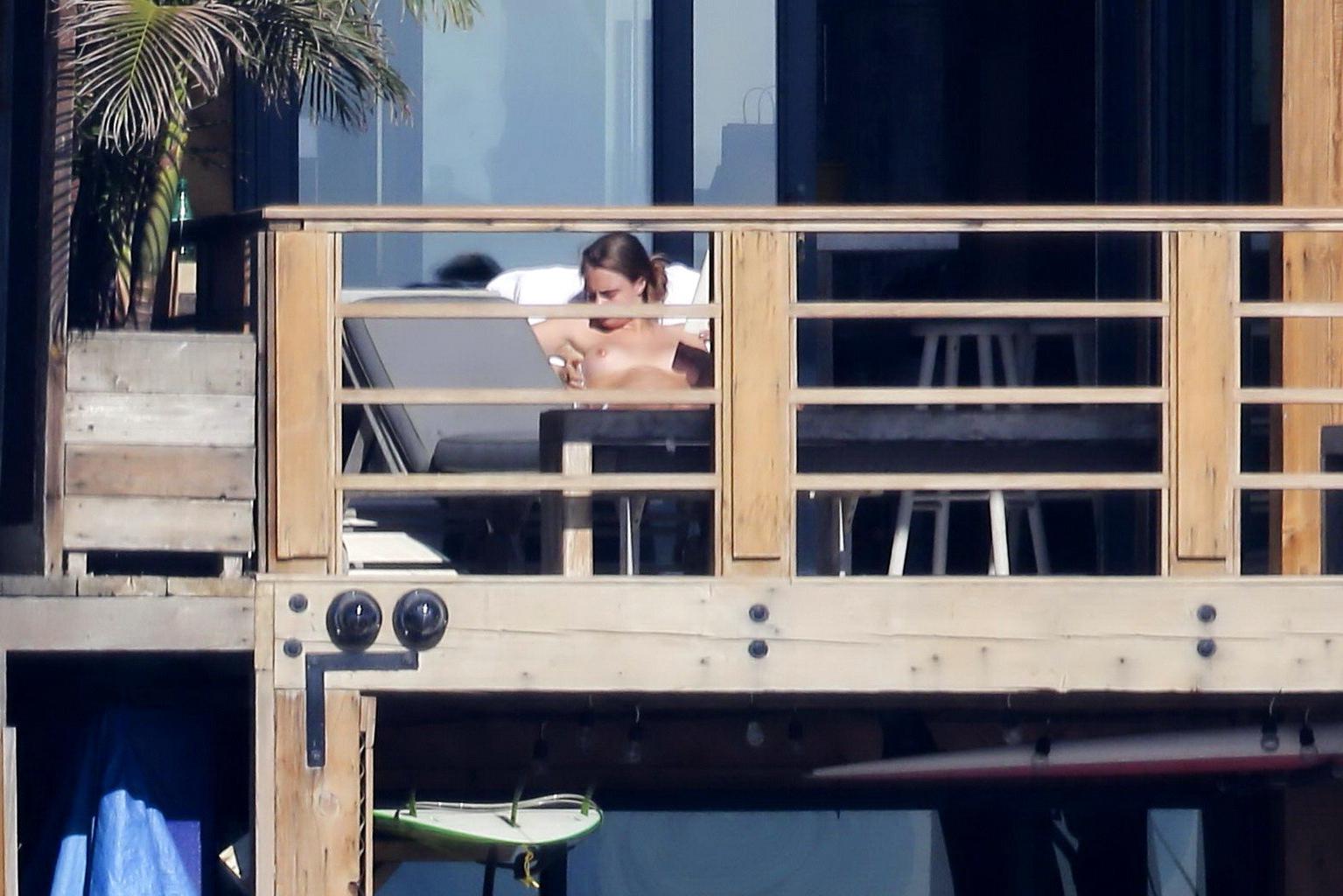 16P Cara Delevingne tanning topless on a balcony in Malibu