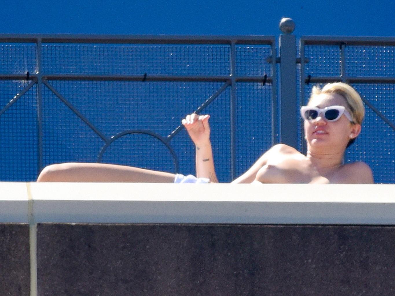 13P Miley Cyrus tanning topless at the hotel balcony in Sydney