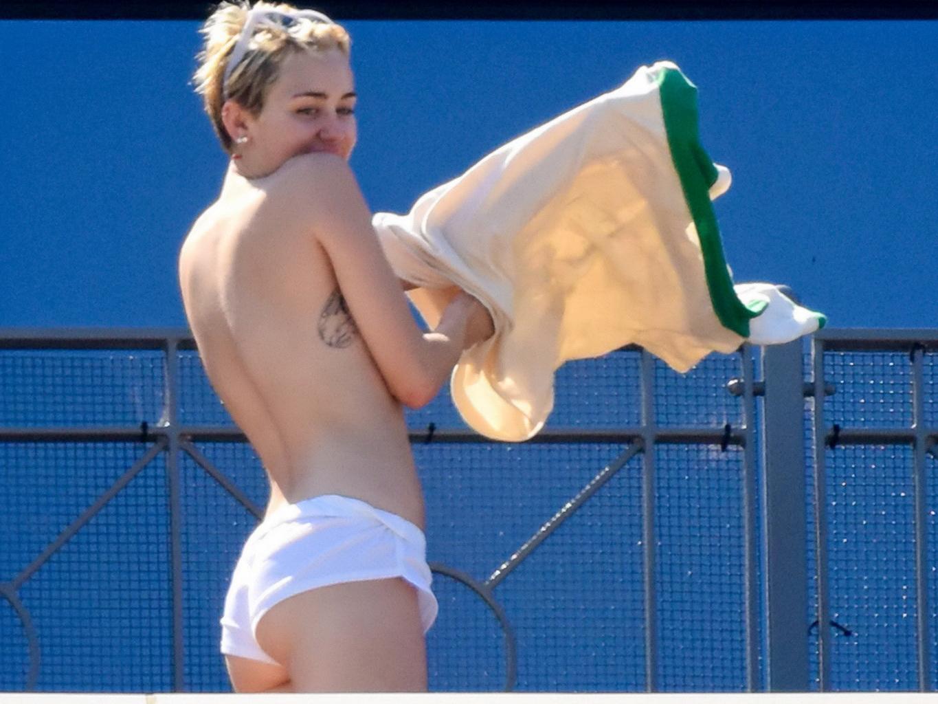 13P Miley Cyrus tanning topless at the hotel balcony in Sydney