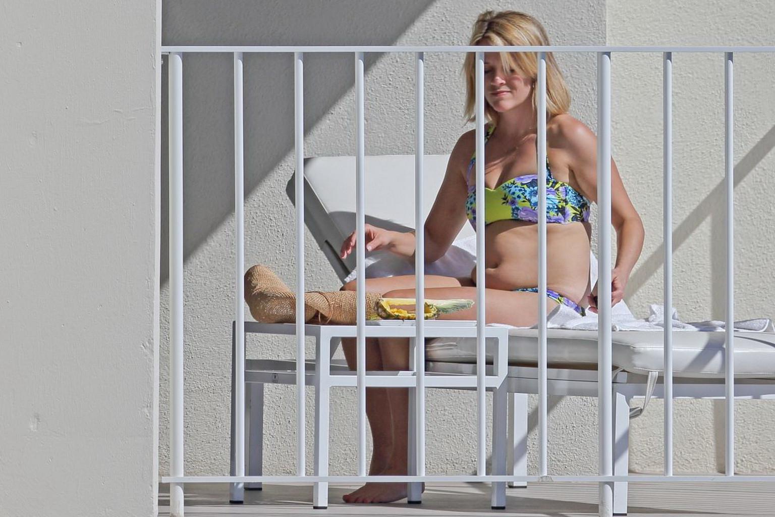 16P Reese Witherspoon wearing a nature colored bikini on a hotel balcony in Hawaii