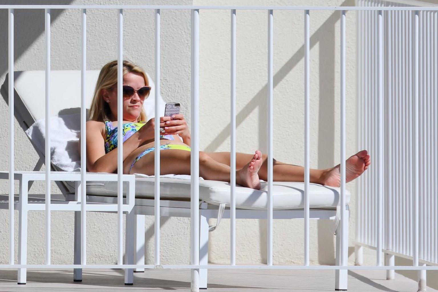16P Reese Witherspoon wearing a nature colored bikini on a hotel balcony in Hawaii
