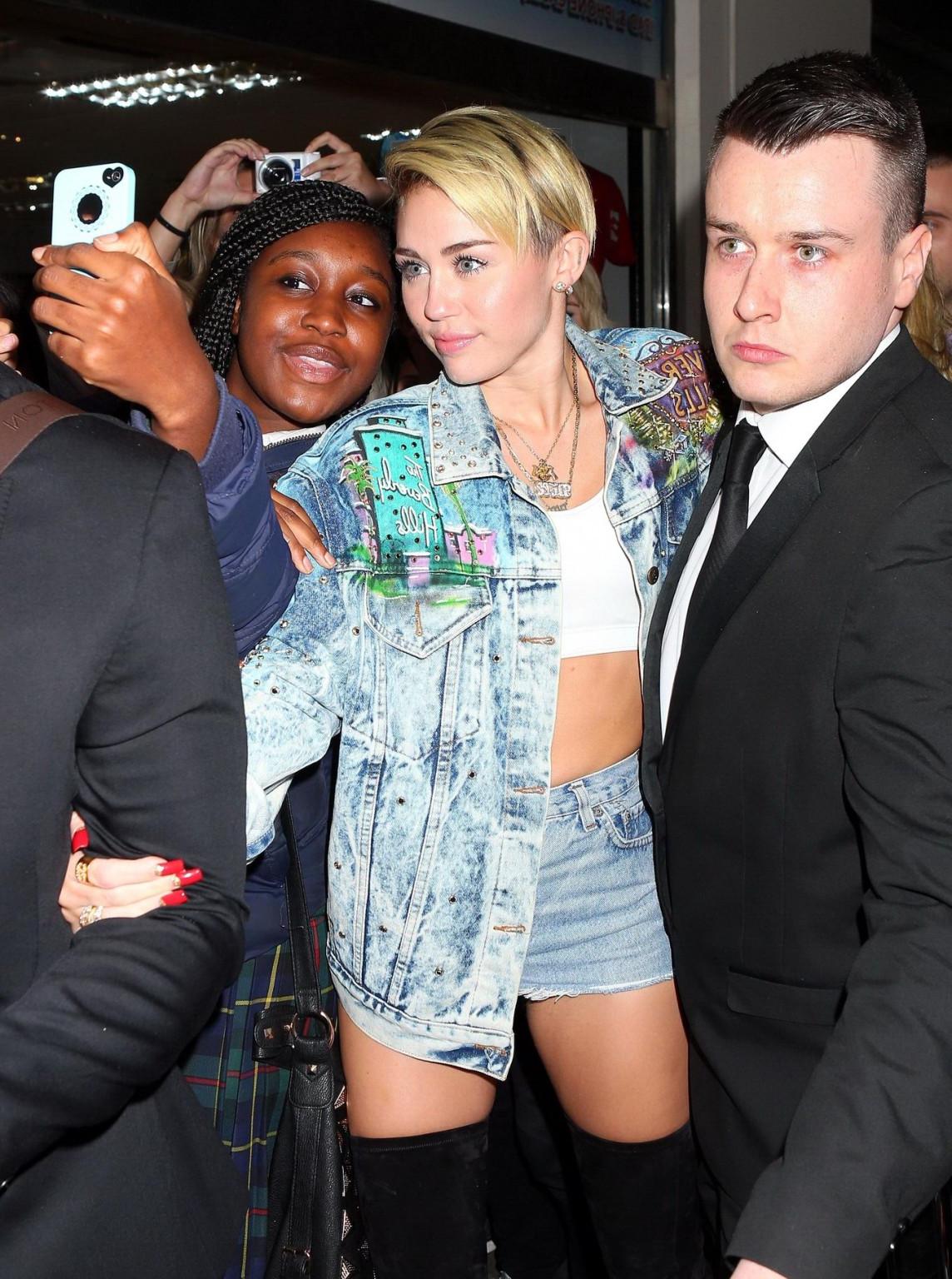 16P Miley Cyrus wearing denim hotpants  fuck-me boots out in London