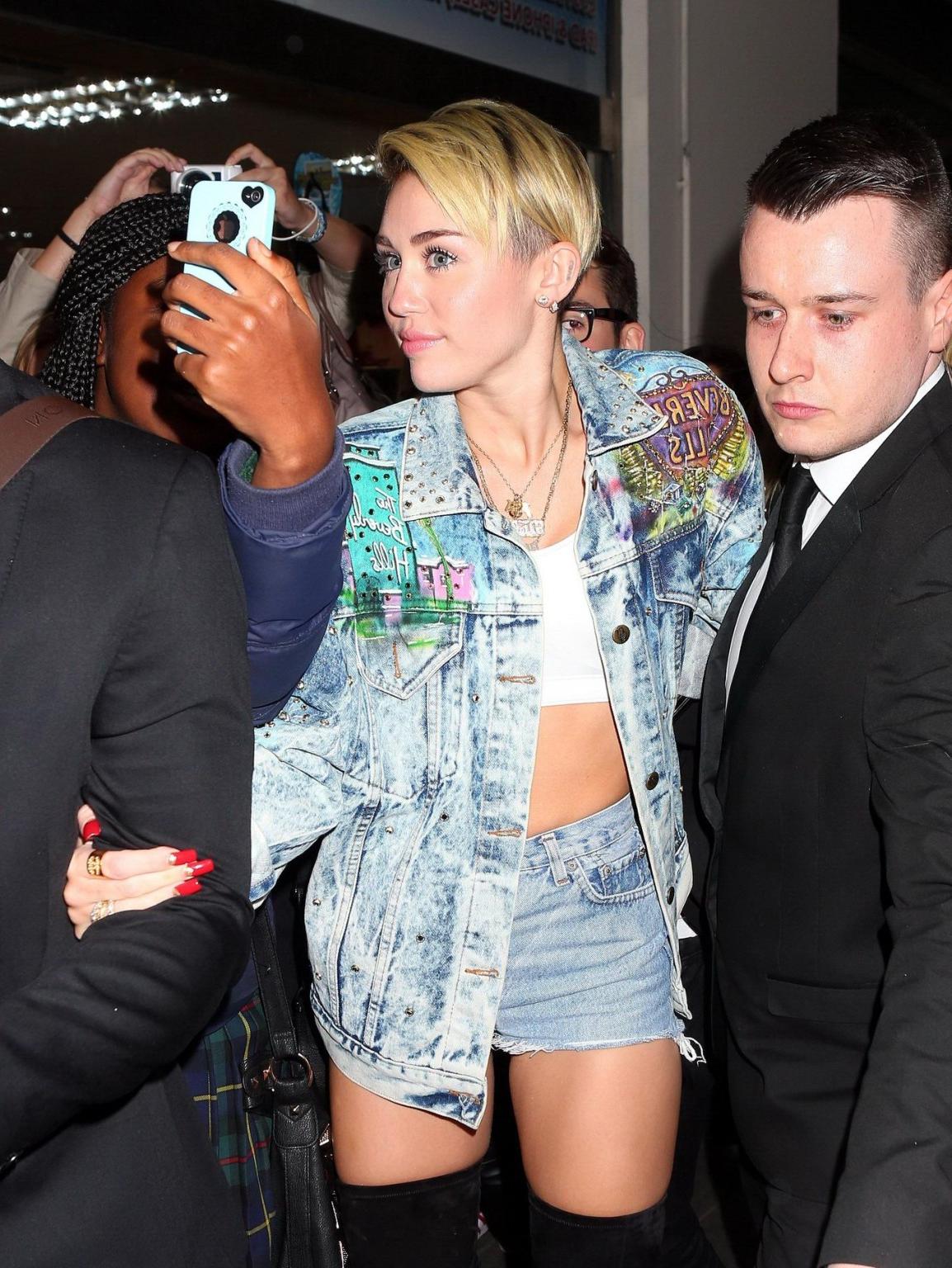 16P Miley Cyrus wearing denim hotpants  fuck-me boots out in London