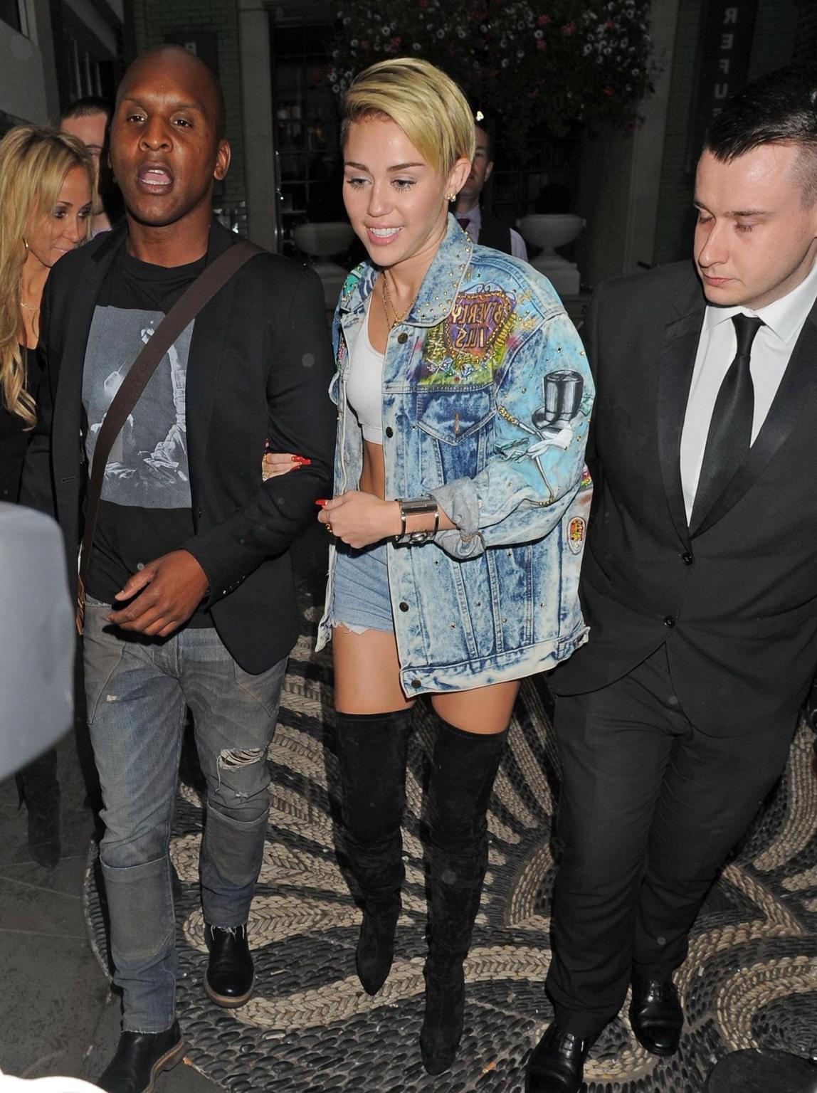 16P Miley Cyrus wearing denim hotpants  fuck-me boots out in London