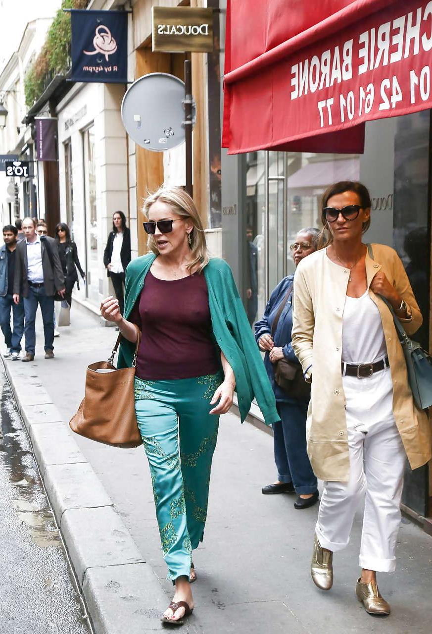 16P Sharon Stone exposing great boobs in see thru shirt on street