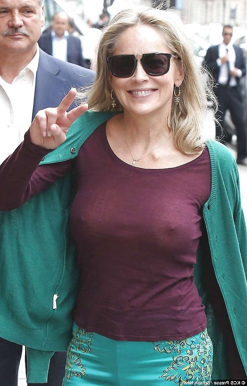 16P Sharon Stone exposing great boobs in see thru shirt on street