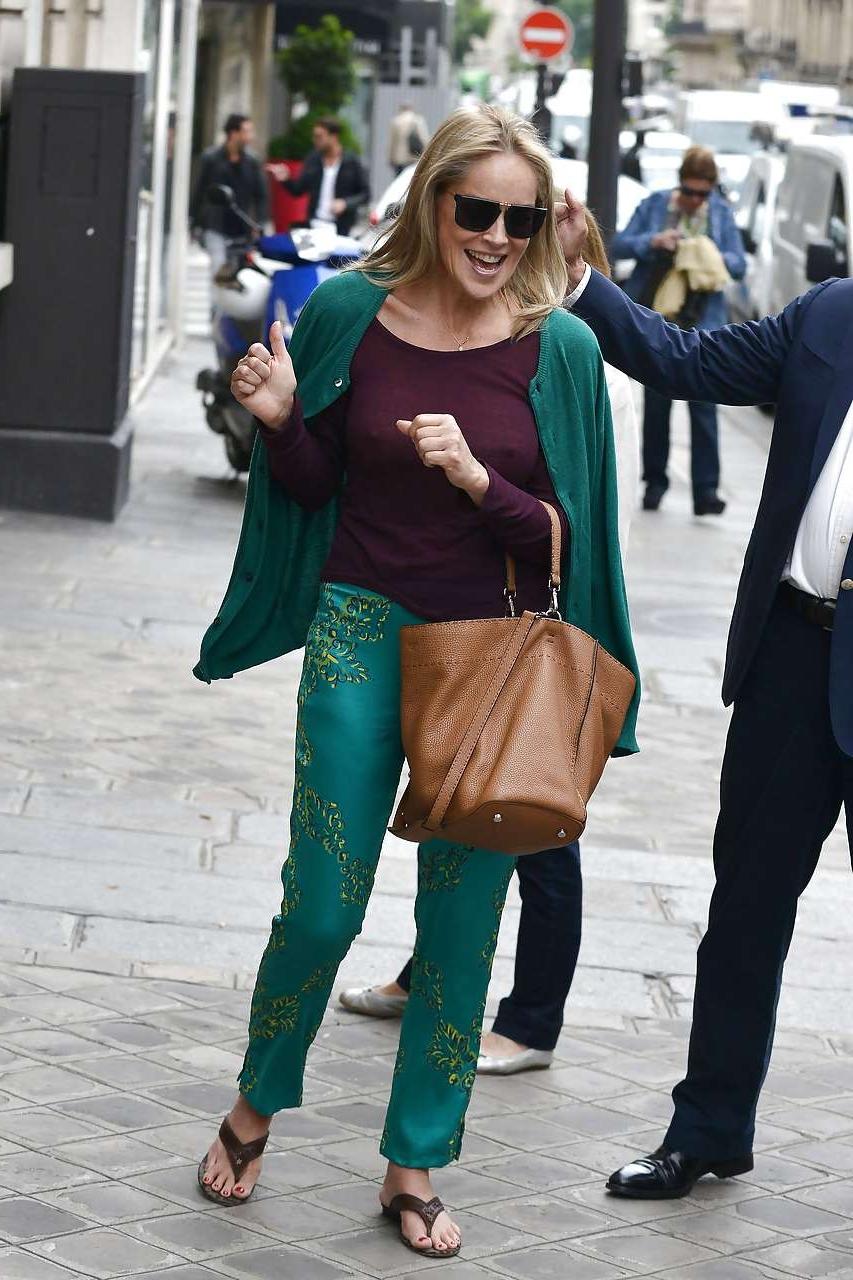 16P Sharon Stone exposing great boobs in see thru shirt on street