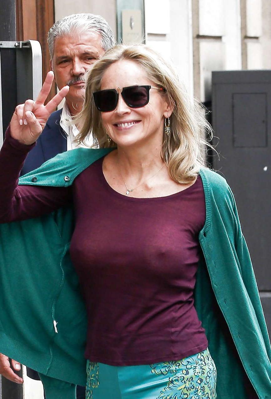 16P Sharon Stone exposing great boobs in see thru shirt on street