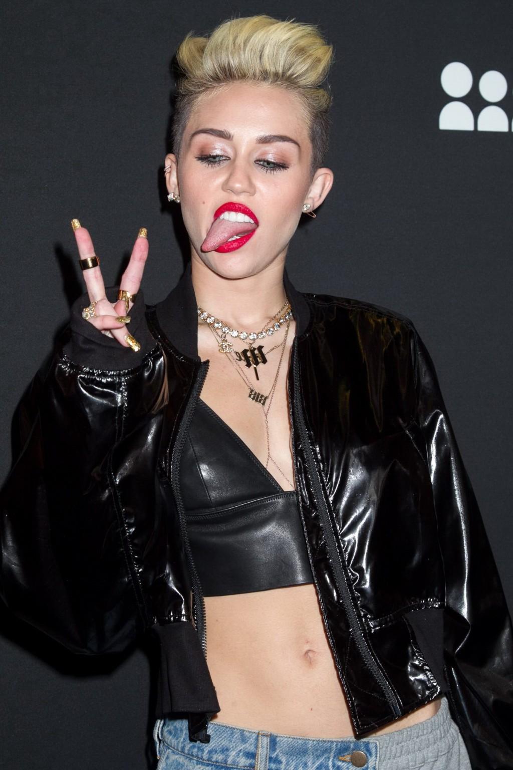 16P Miley Cyrus wearing a leather crop top at the Myspace launch event