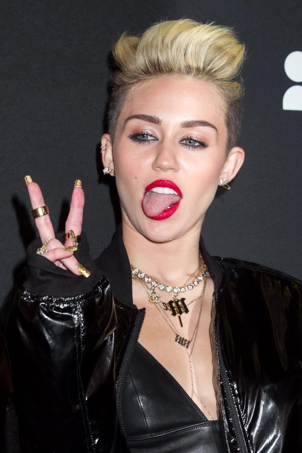 16P Miley Cyrus wearing a leather crop top at the Myspace launch event