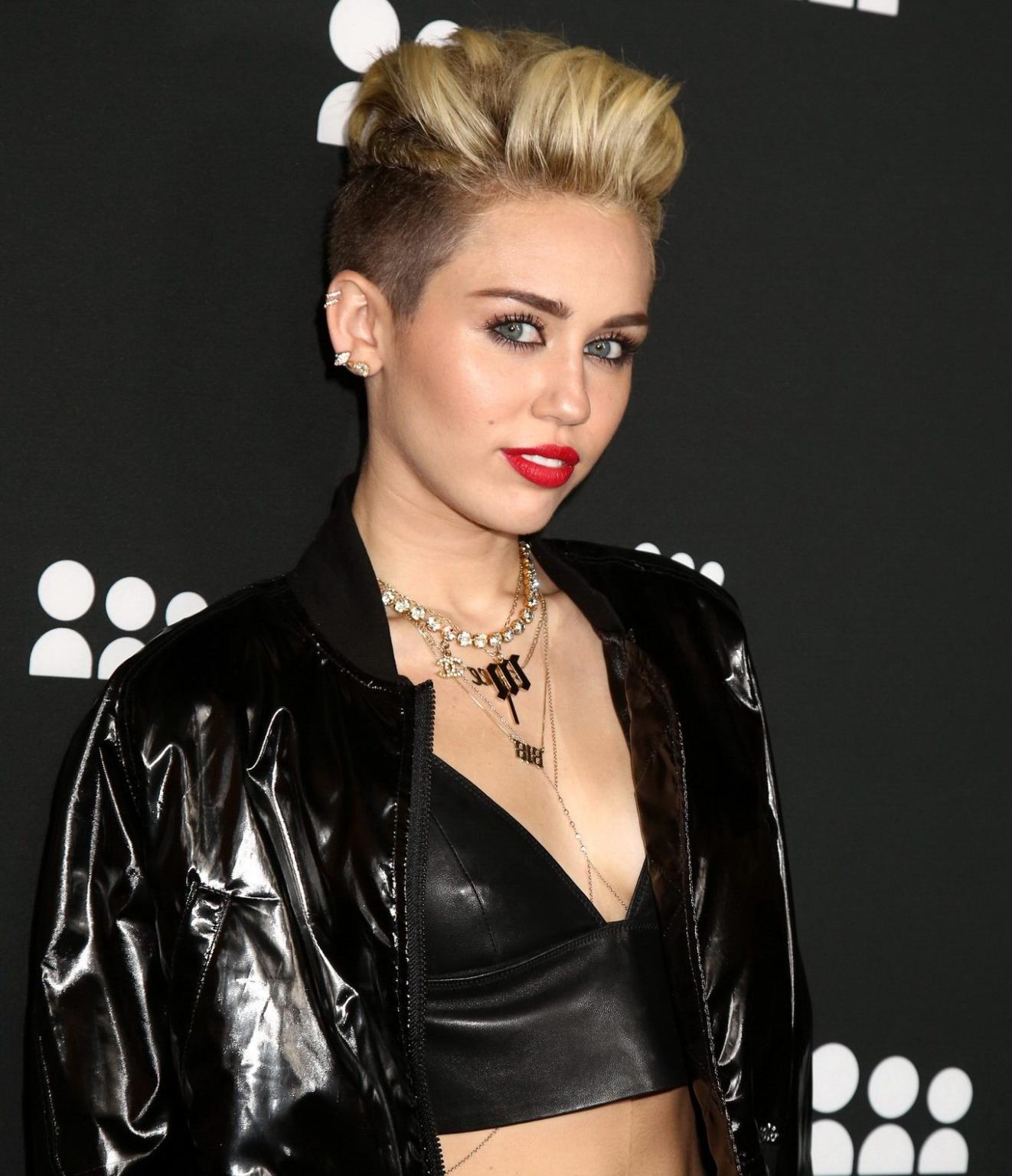 16P Miley Cyrus wearing a leather crop top at the Myspace launch event