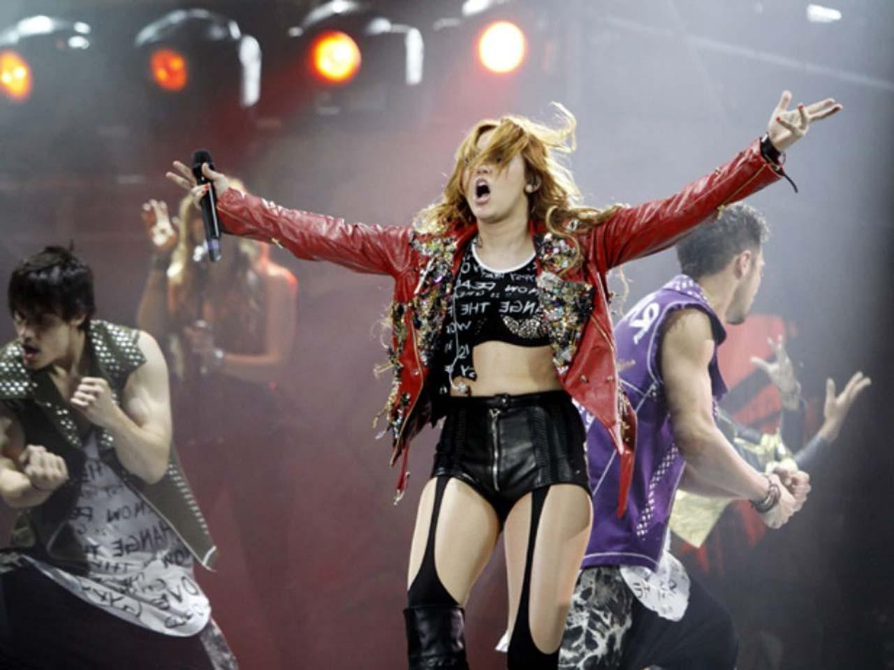 16P Miley Cyrus showing huge cleavage and lot of legs in shorts and high boots on st
