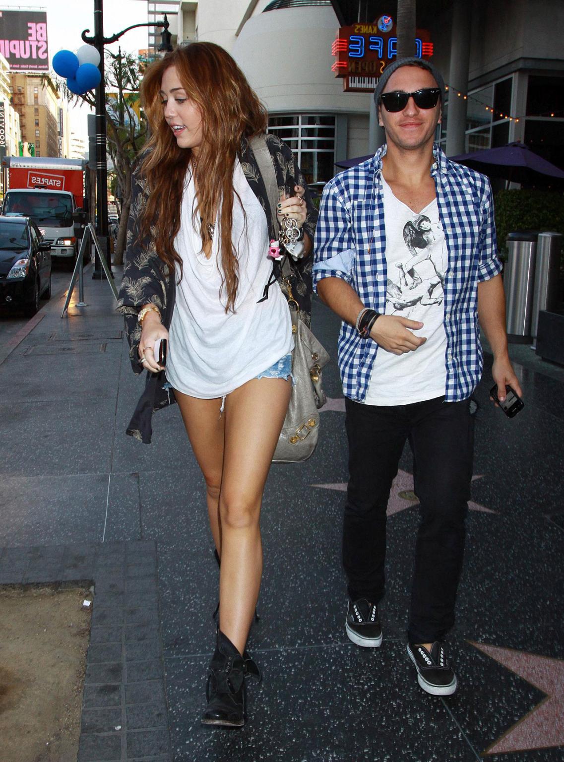 10P Miley Cyrus showing sexy legs on street while she walking with friend