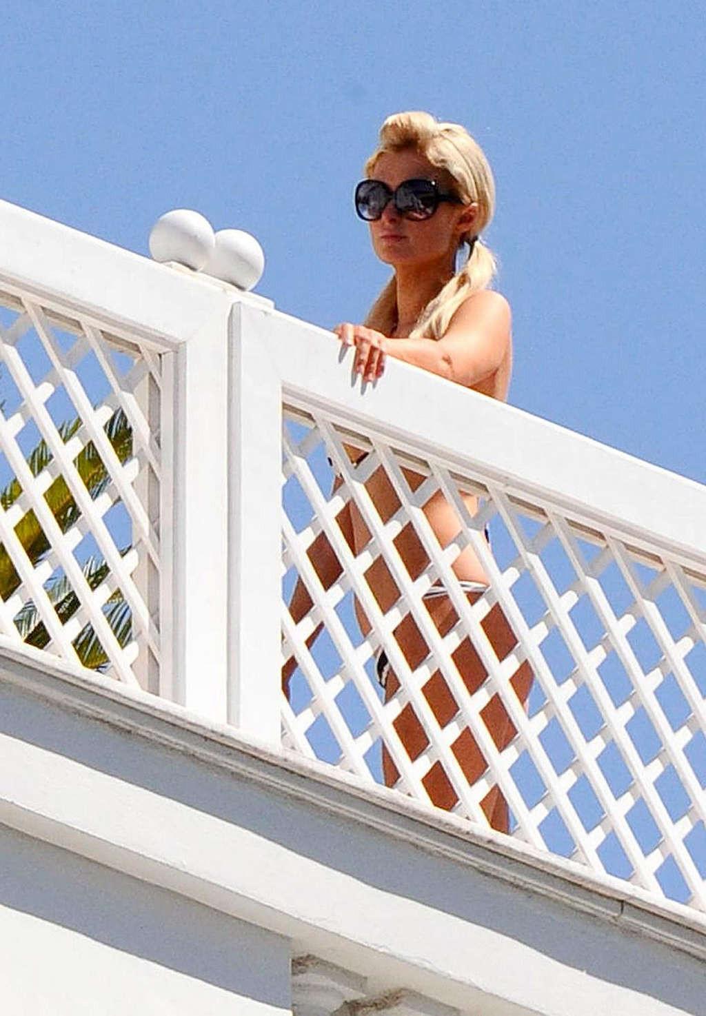 10P Paris Hilton showing her nice ass in thong on balcony and in see thru dress