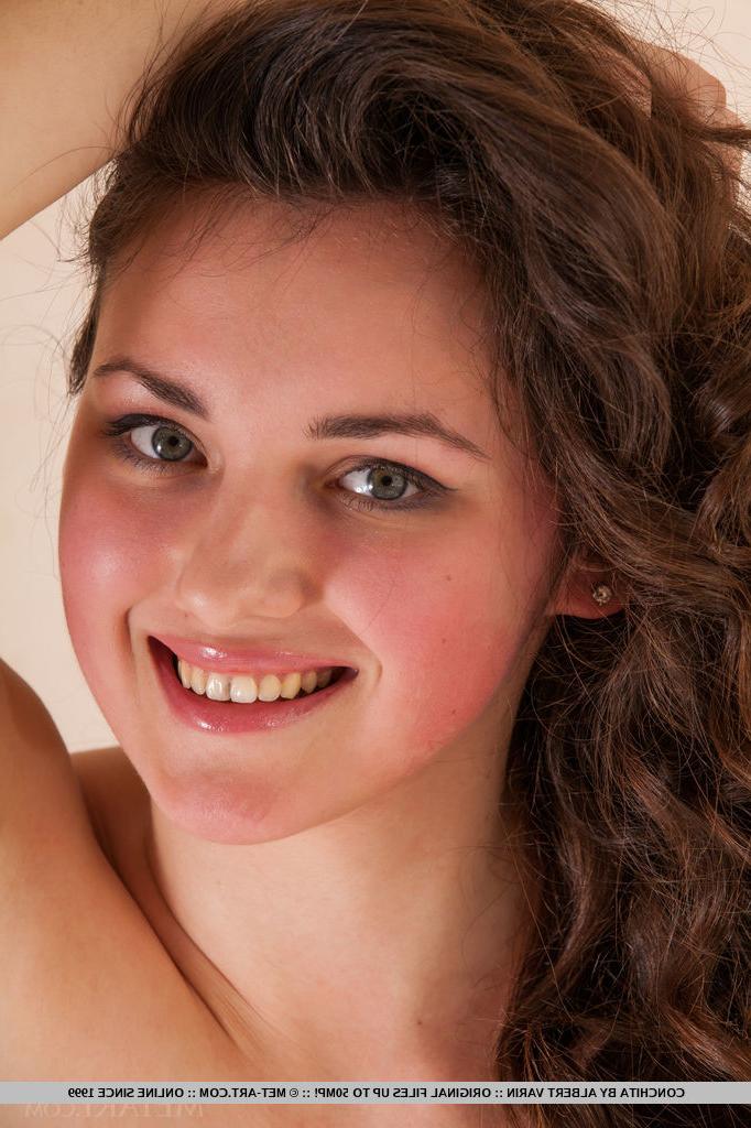 18P Brunette Conchita showing off small tits & flaunting shaved pussy close up