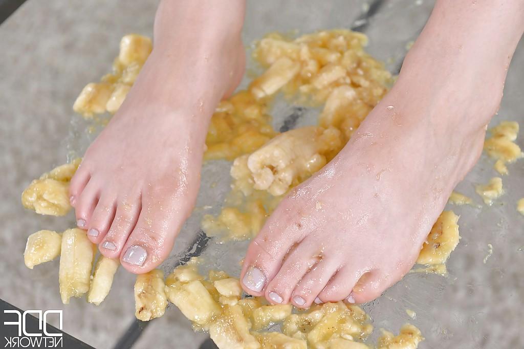 16P Leggy babe Ariana Brown squashing banana with barefeet after socks removal