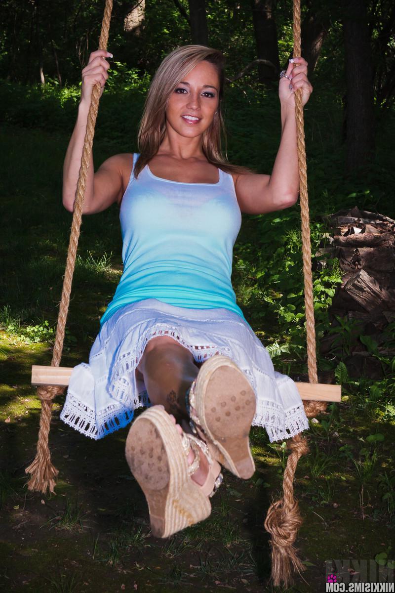15P Busty beauty Nikki Sims strips to her panties and swings