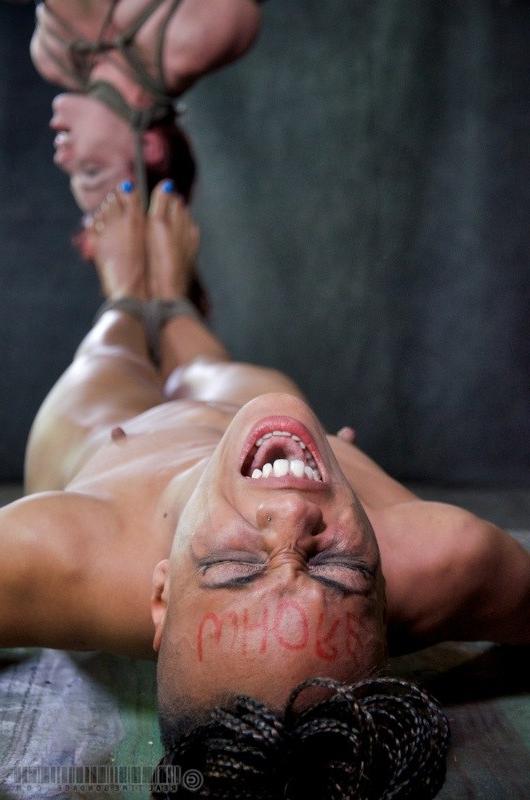 16P Nikki Darling and Bella Rossi bound together in a dark dungeon