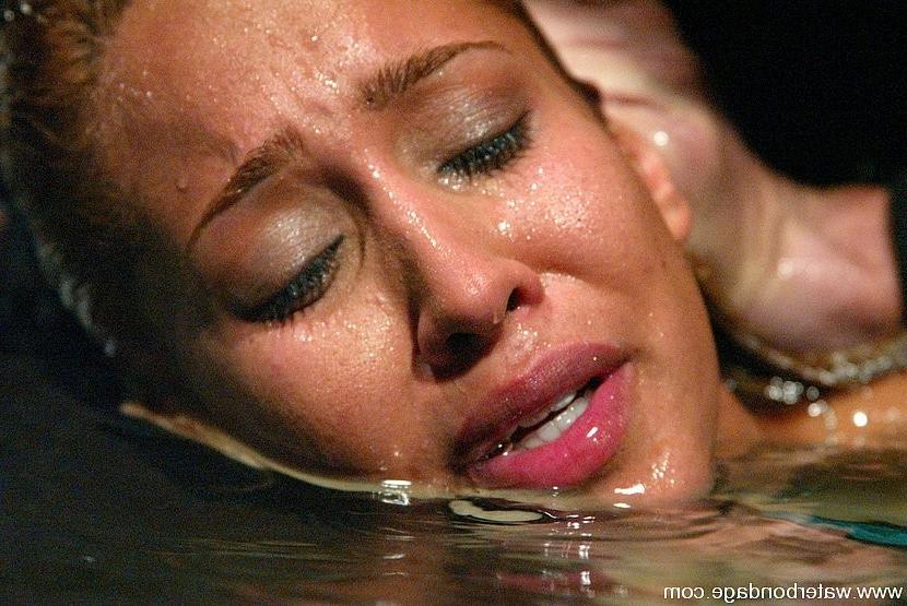 15P Isis Love blonde is rope bound in watertank and put on ice