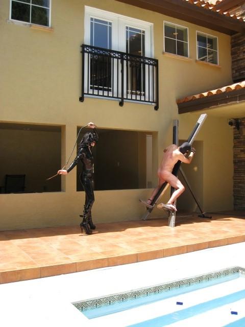 10P Latex clad femdom brutally whips male sub bound to xframe