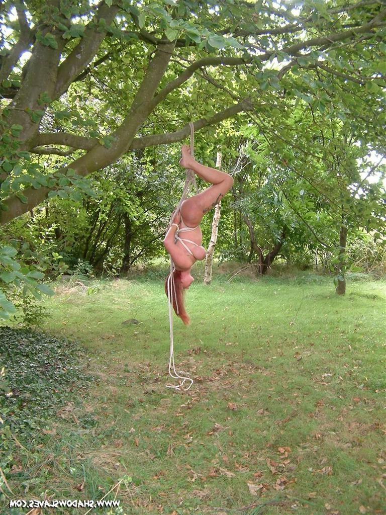 15P Slave girl is tightly bound in rope and suspended from a tree