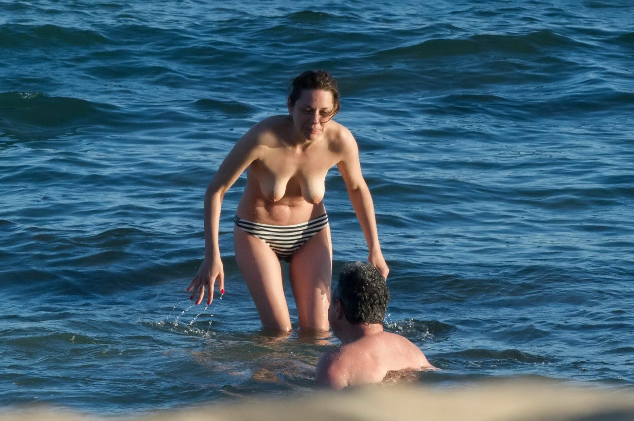 16P Marion Cotillard swimming topless at the beach