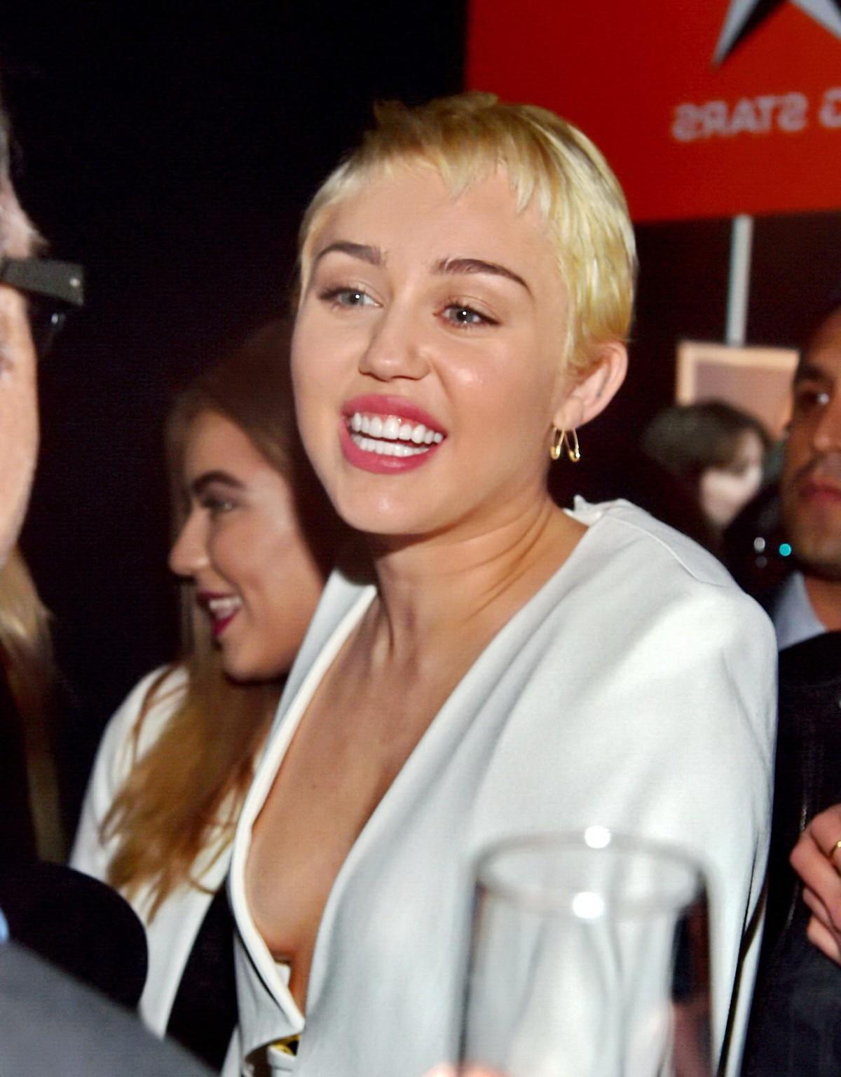 16P Miley Cyrus braless shows cleavage attending the W Magazine Shooting Stars Exhib