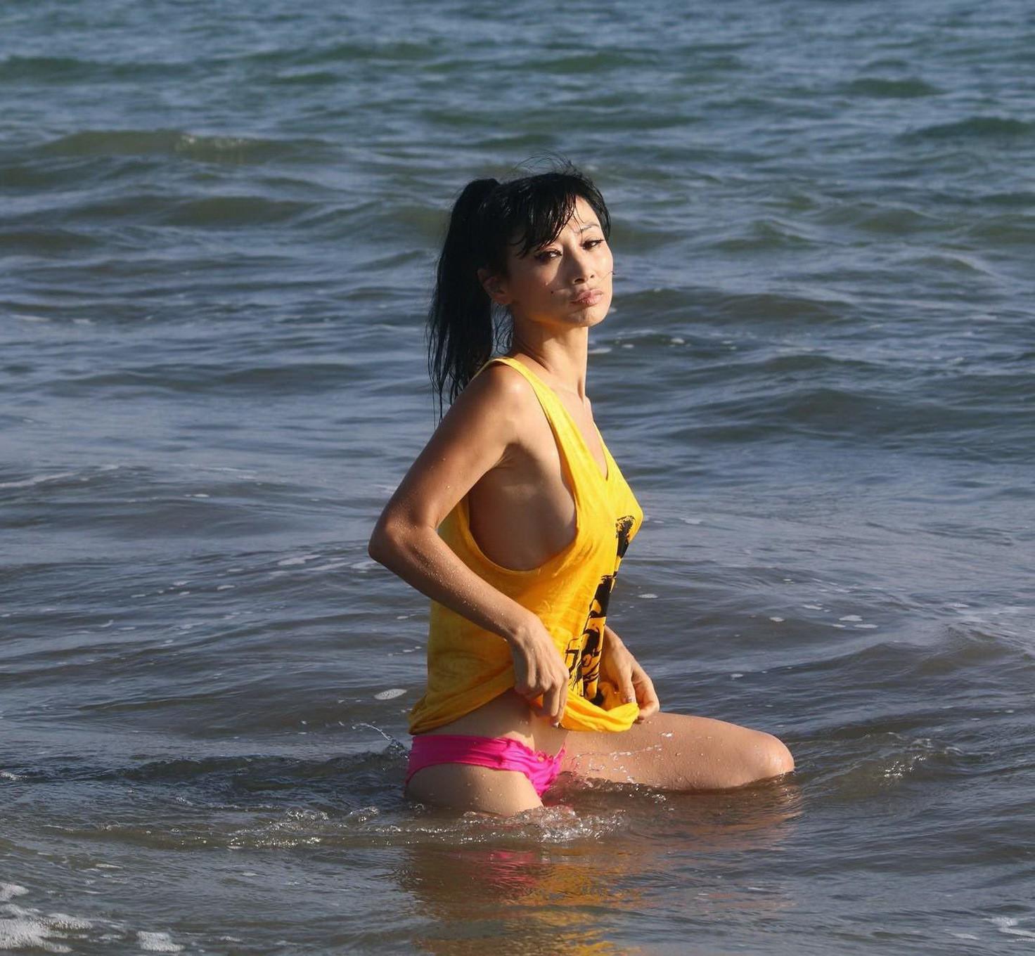 16P Bai Ling shows sideboob and pokies in wet tshirt and bikini bottom at the beach 