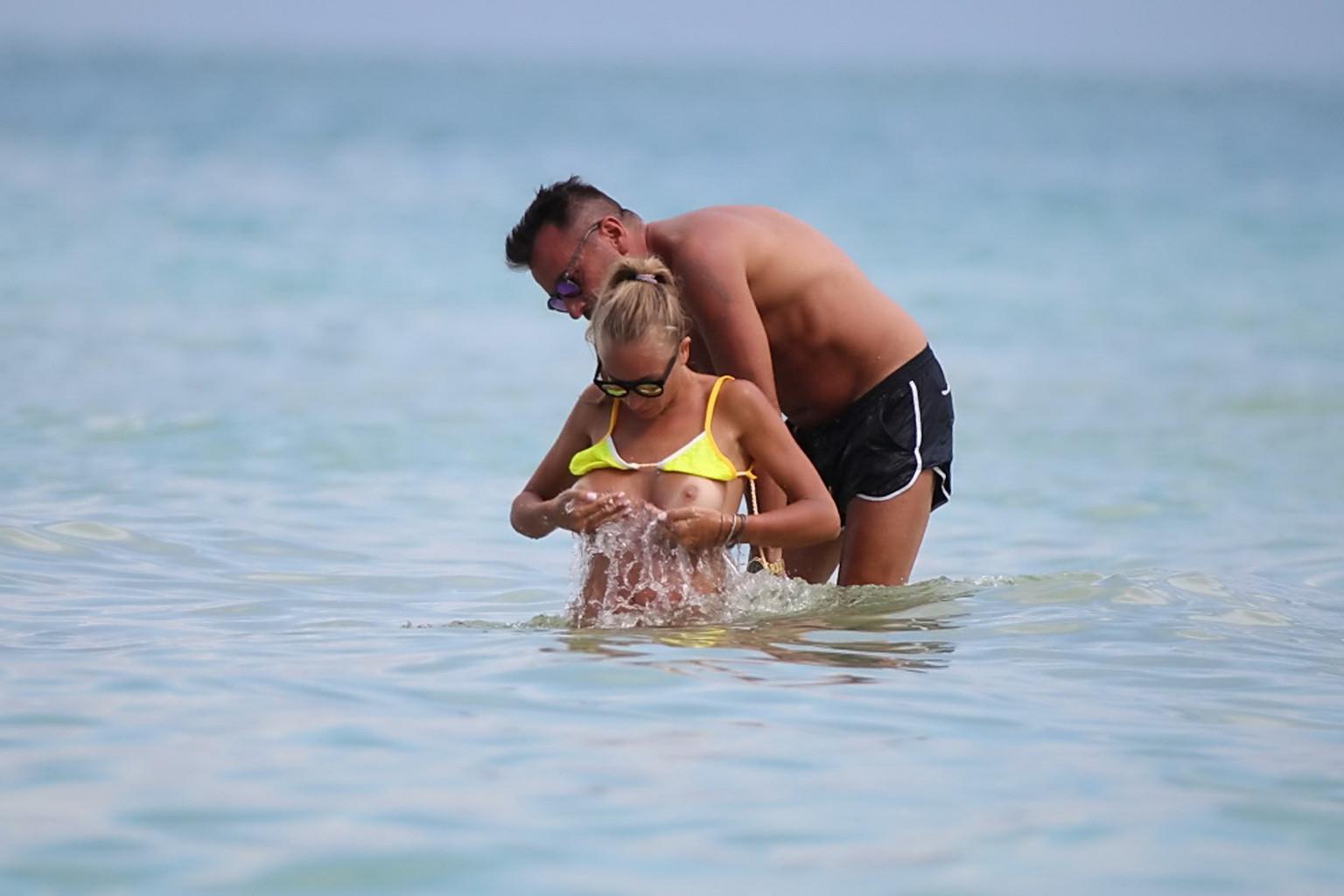 16P Laura Cremaschi topless and getting groped in a yellow thong bikini at a beach i