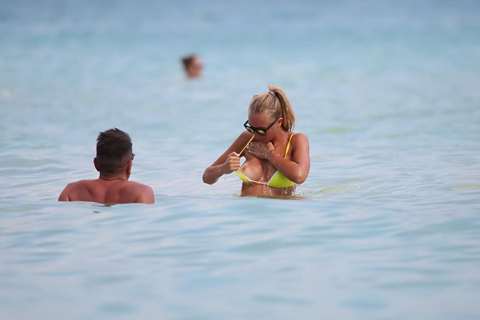 16P Laura Cremaschi topless and getting groped in a yellow thong bikini at a beach i