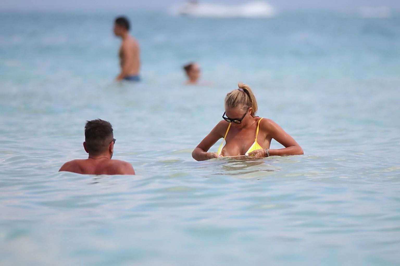 16P Laura Cremaschi topless and getting groped in a yellow thong bikini at a beach i