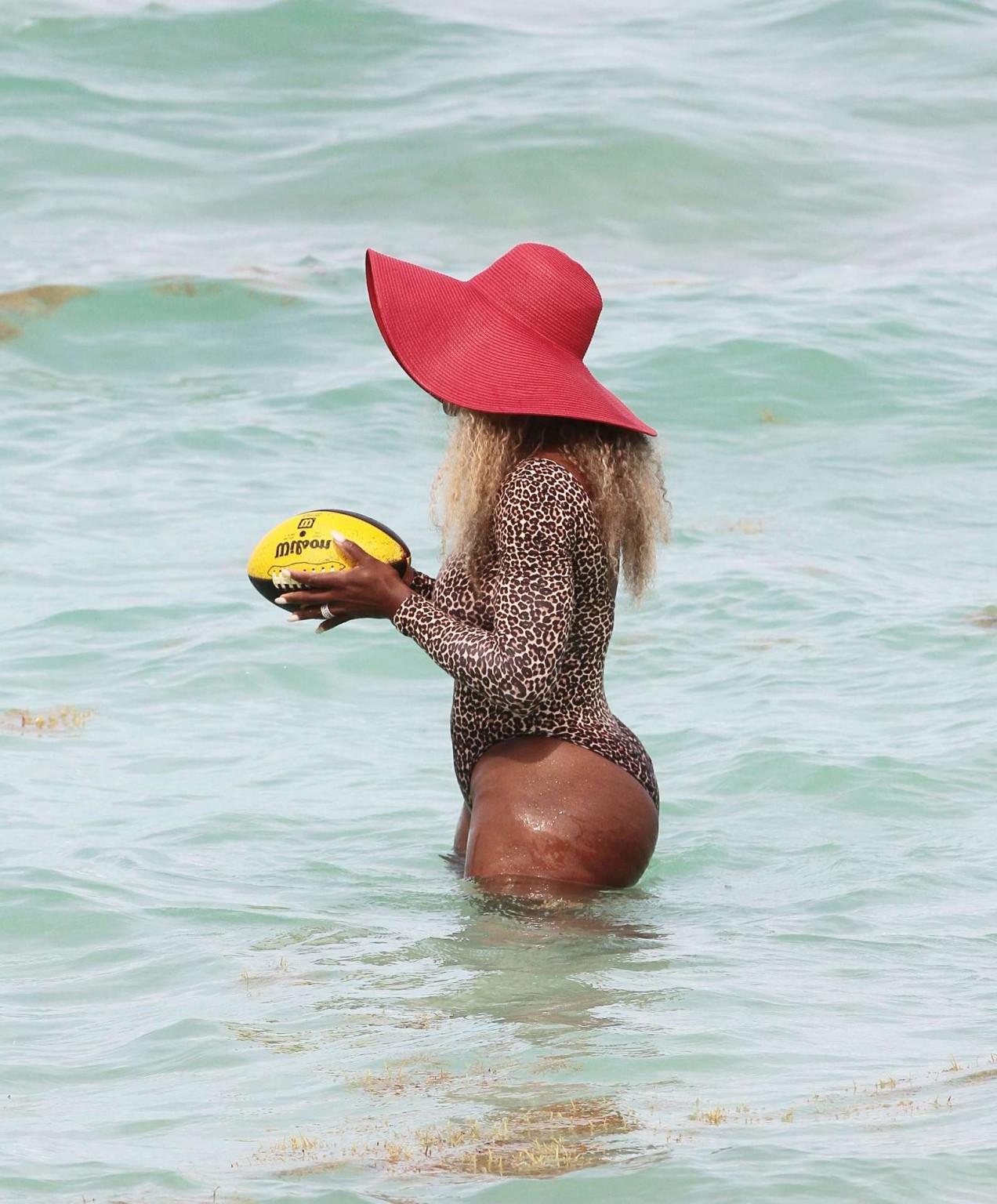 16P Serena Williams shows off her curvy body wearing a leopard print swimsuit on a b