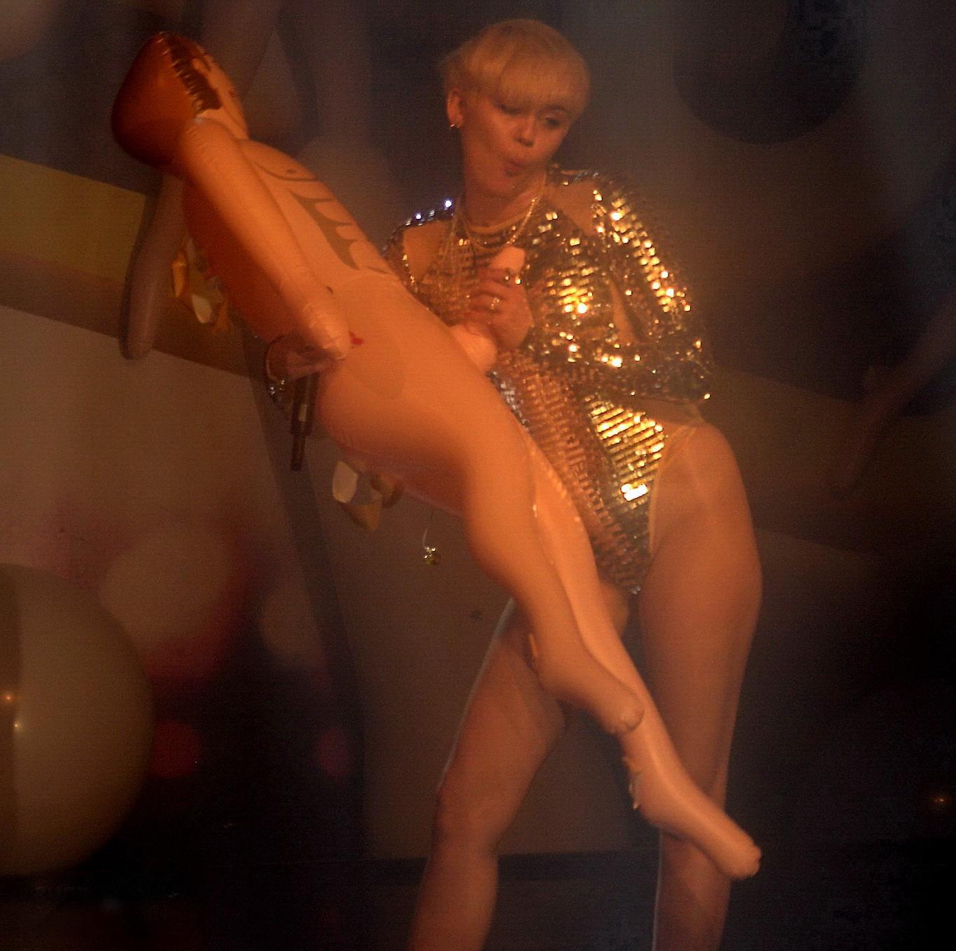 16P Miley Cyrus giving a blowjob to a blow up doll on stage at GAY Club in London